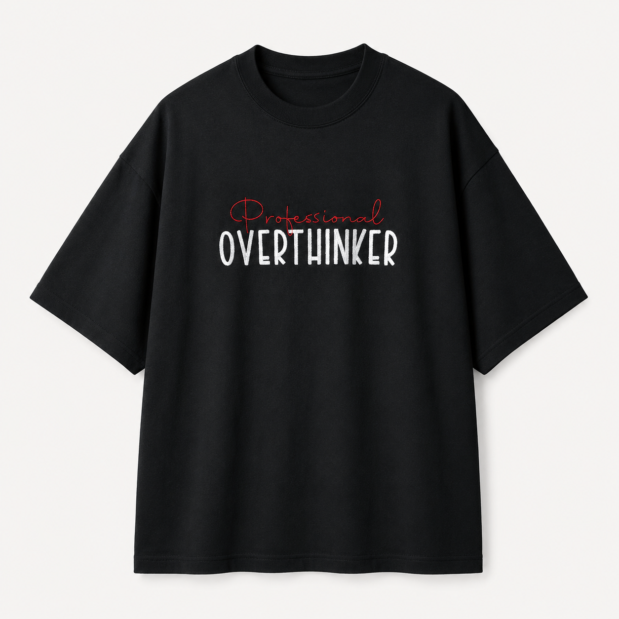 A black short-sleeve crewneck t-shirt with a graphic text print on the chest reading 'Professional OVERTHINKER' in white and red, displayed against a light gray background.