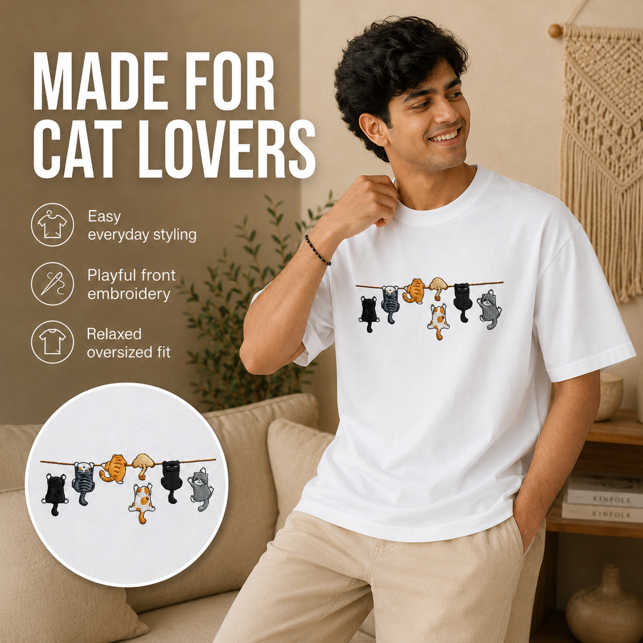 A man wearing a white crewneck t-shirt with a graphic of cartoon cats hanging on a clothesline, posed in a cozy living room setting. The image includes marketing text on the left highlighting features like 'Easy everyday styling' and 'Playful front embroidery', along with a circular inset showing the embroidery detail.