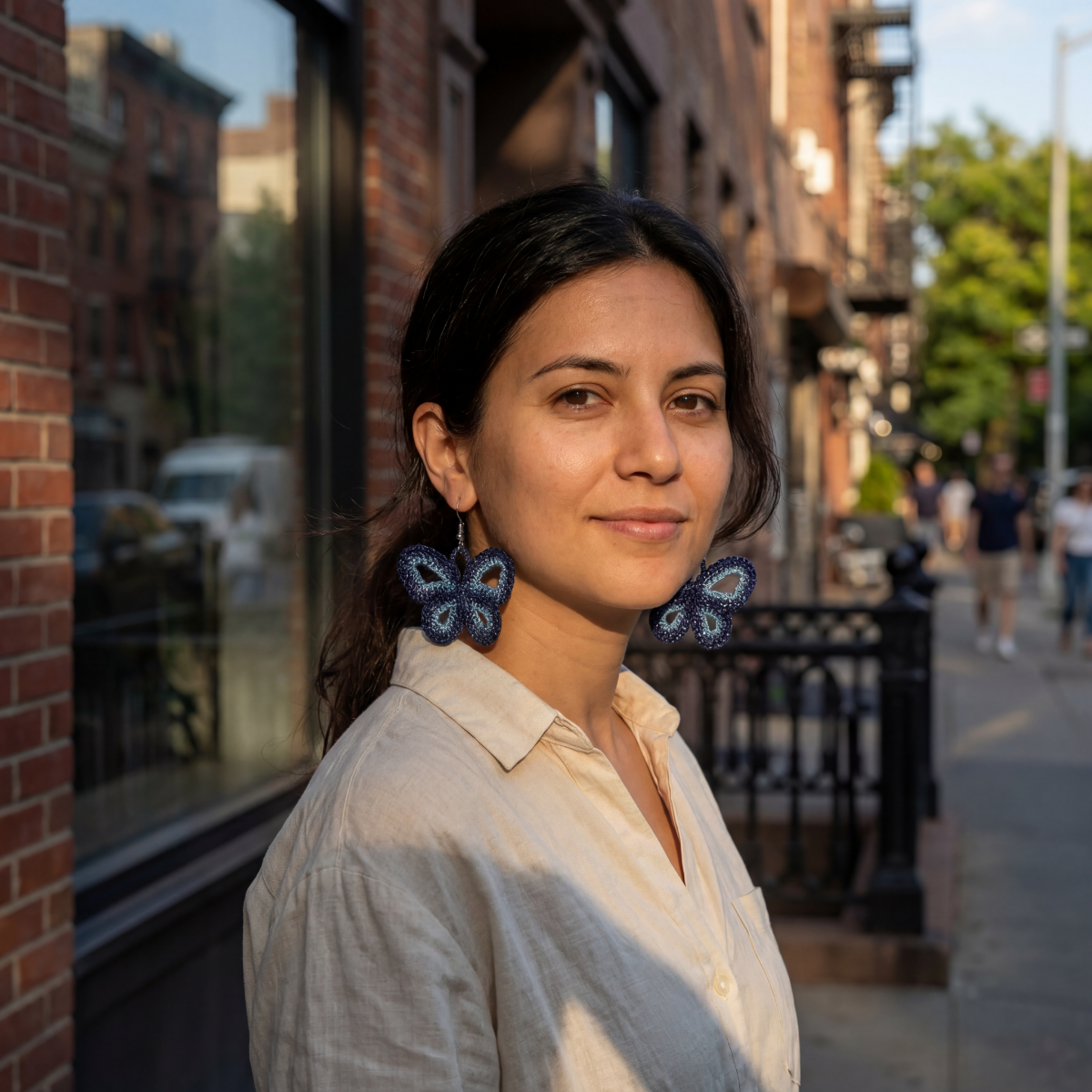Woman with butterfly earrings standing on a city street