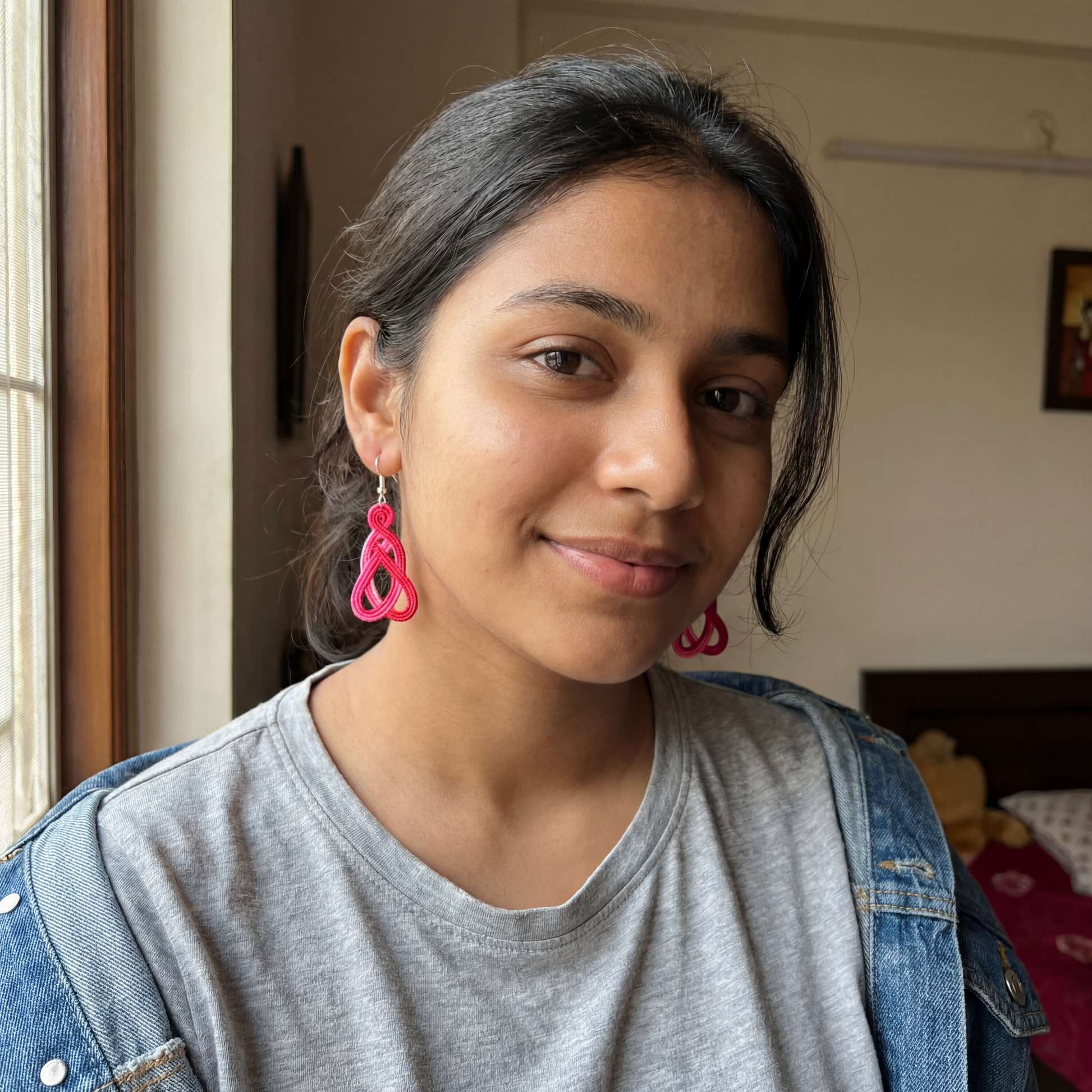 Person wearing pink earrings in a casual setting