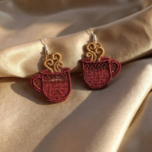 Red mug earrings on a beige fabric background