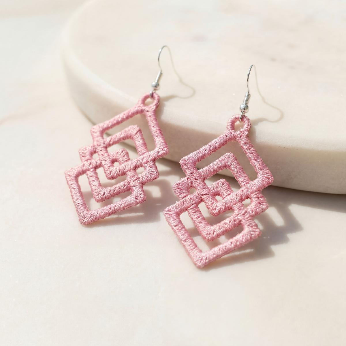 Pink crochet earrings on a light pink background