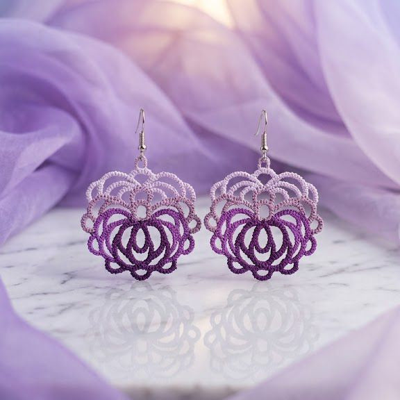Purple floral earrings on a soft purple fabric background