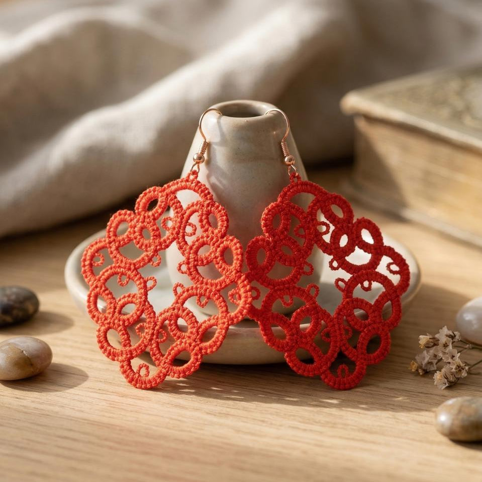 Red lace earrings on a wooden surface with a neutral background