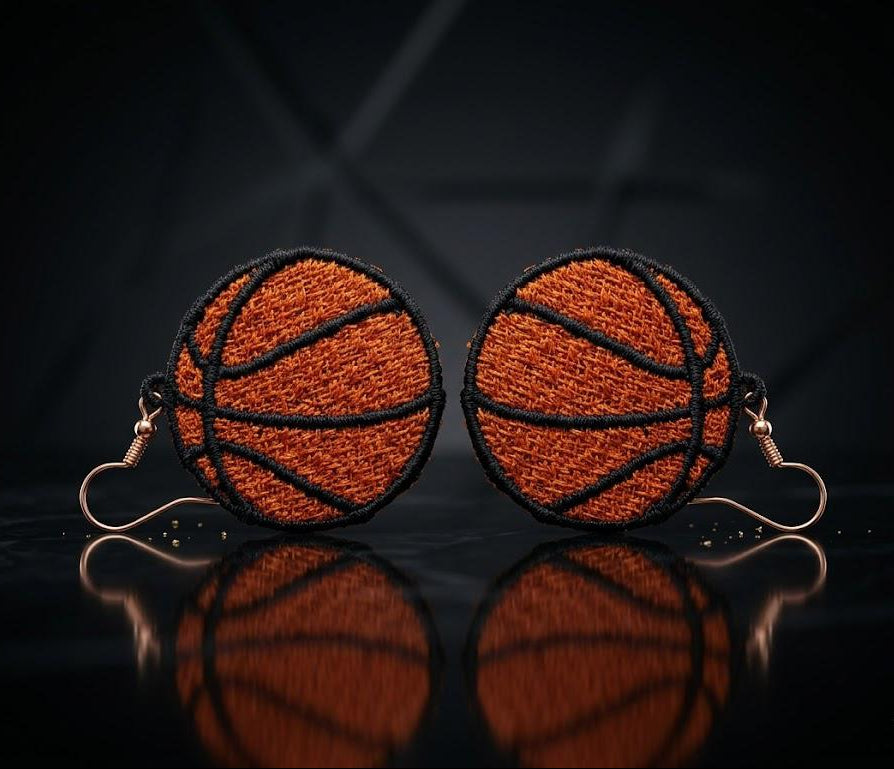 Basketball-themed earrings on a reflective surface with a dark background